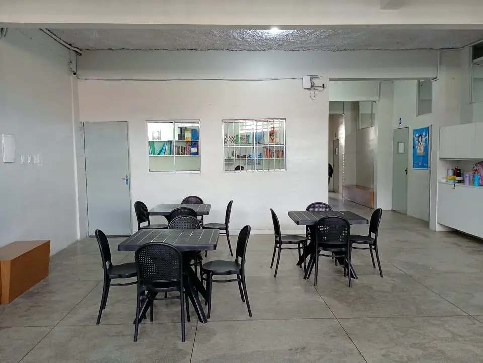 Área de convivência da escola com mesas e cadeiras