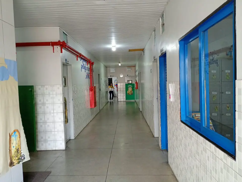 Corredor da escola com janelas azuis e armários dos alunos